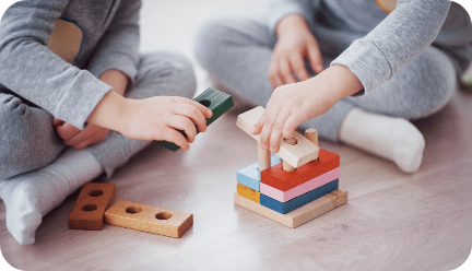 Dos niños jugando con piezas de madera