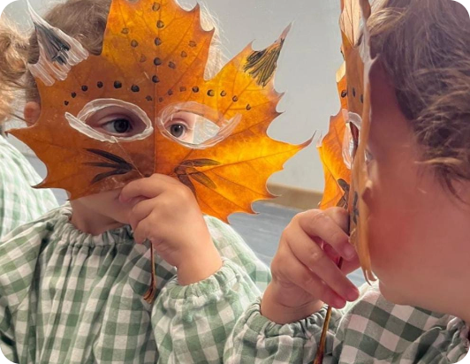 Niña con una hoja con forma de máscara